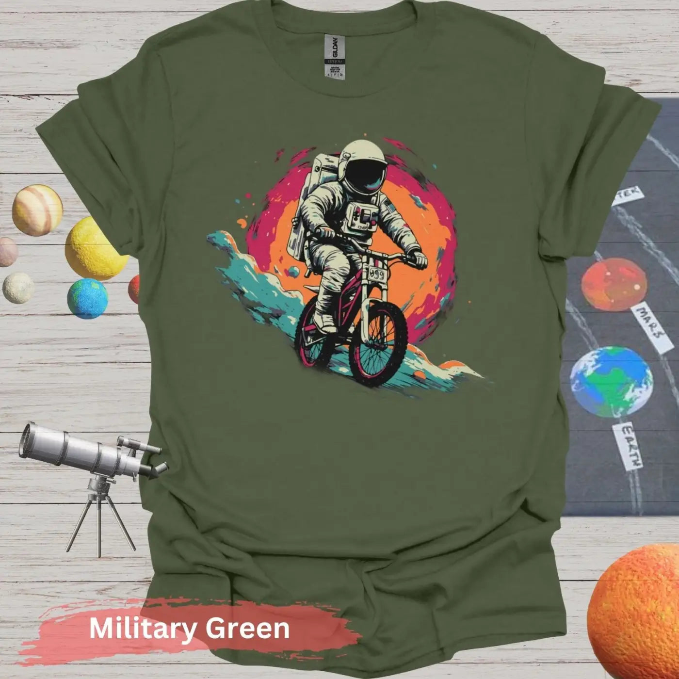 Cosmic Cyclist: Astronaut Biking Adventure T-Shirt - S - Unisex / Military Green - Physical Item